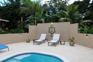 a patio with two chairs and a swimming pool at Sueño Río Celeste Boutique B&B in Bijagua