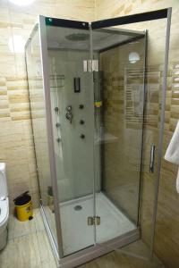 a shower with a glass door in a bathroom at Pensiunea Luminita in Târgu Jiu