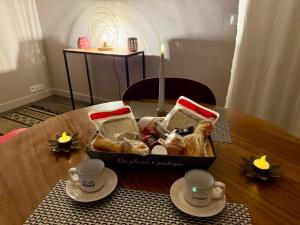 a basket of food on a table with two cups at Maison avec Spa Privatif, Jacuzzi et Sauna in Bailleval +11 photos