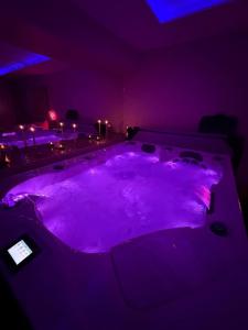a purple room with a jacuzzi tub with lights at Maison avec Spa Privatif, Jacuzzi et Sauna in Bailleval