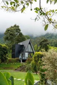 a glass house in the middle of a garden at AREWÁ Biohabitat in Buenavista