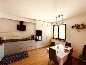 a kitchen with a table and a dining room at APARTAMENT RYBICAL nad jeziorem in Ryn