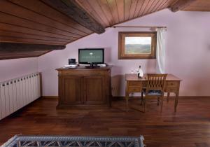 a living room with a tv and a desk with a computer at Locanda degli Ulivi in Arcugnano