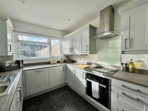 a kitchen with white cabinets and a sink and a window at Stylish 2-Bed Home with Garden in Saint Thomas Station +10 photos