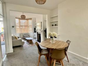 a living room with a wooden table and chairs at Stylish 2-Bed Home with Garden in Saint Thomas Station