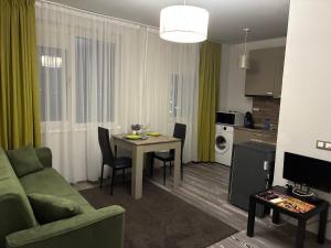 a living room with a table and a couch and a kitchen at Апартамент Димана in Hisarya +8 photos