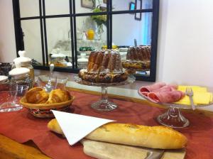 a table with bread and pastries on a table at Coté Cour Bischwihr Colmar 2 in Bischwihr +42 photos