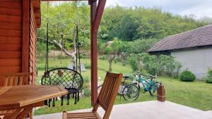 a patio with a table and two bikes on the grass at Faluvégi Vendégház in Cserépváralja