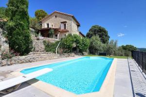 a swimming pool in front of a house at La Rochere in Sampzon