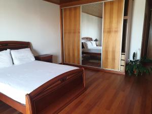 a bedroom with a bed and a large mirror at Farol Golfe in Ponta do Pargo