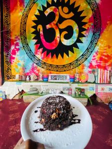 a person holding a plate with a chocolate dessert on it at Mj home in Kalgha