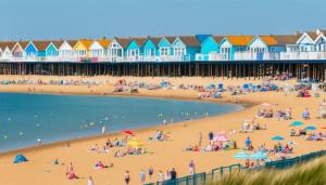 a group of people on a beach with houses at Caravan in Clacton-on-Sea in Little Clacton