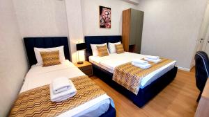 ein Hotelzimmer mit zwei Betten, auf denen Handtücher liegen in der Unterkunft Falcon Hotel in Tbilisi City