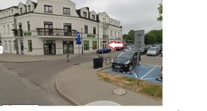 a car parked on a street in front of a building at ABCD Apartments Centrum in Biała Podlaska