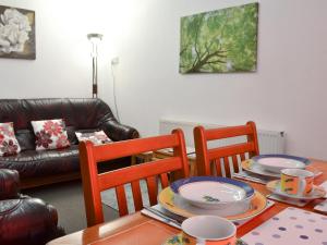 a dining room table with chairs and plates on it at Tanpencefn Mawr in Brynsiencyn