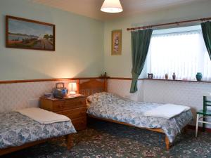 a hotel room with two beds and a window at Tanpencefn Mawr in Brynsiencyn
