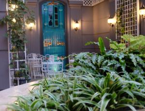 a porch with a blue door and some plants at d'Primahotel Bandung in Bandung
