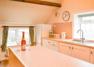 a kitchen with two wine glasses on a counter at Summertree Farm The Granary in Thornton Dale +18 photos