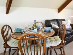 a dining room table with chairs and a couch at Summertree Farm The Granary in Thornton Dale