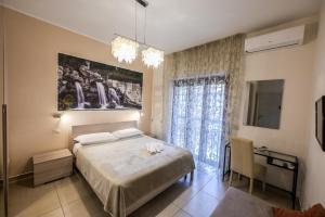a bedroom with a bed and a desk and a window at Le Fontane del Re in Caserta