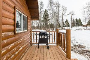a grill on the porch of a log cabin at The Sheep Camp cabin- Bear Creek Cabins in Winfield