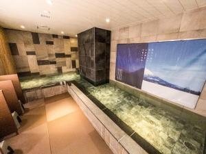 a large tub in a bathroom with a large window at HOTEL RELIEF Sapporo Susukino in Sapporo