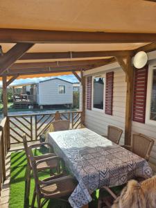 a patio with a table and chairs on a deck at camping siblu le montourey fréjus in Fréjus