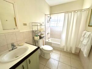 a white bathroom with a sink and a toilet at Krysta's Hideaway in Basseterre +11 photos