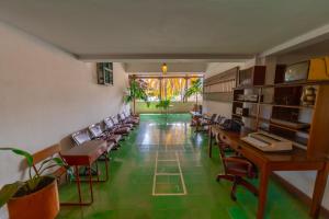 a room with desks and chairs and a green floor at Hotel Mariscal Robledo in Santa Fe de Antioquia