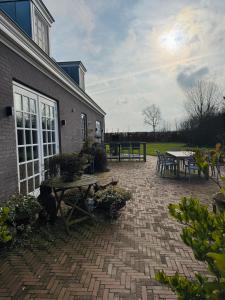 a brick patio with tables and benches next to a building at Het Koetshuis in Zwolle