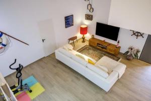a living room with a white couch and a flat screen tv at Casa dos Andrades in Sesimbra