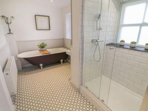 a bathroom with a bath tub and a shower at Bwthyn Mawr in Harlech +27 photos