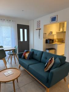 a living room with a blue couch and a table at La Belle Prise in Matougues