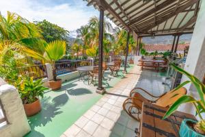 a patio with tables and chairs and palm trees at Hotel Mariscal Robledo in Santa Fe de Antioquia
