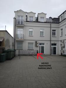 a large white building with a red arrow in front of it at ABCD Apartments Centrum in Biała Podlaska +4 photos