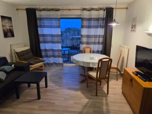 a living room with a table and a dining room at Apartmentanlage am Kellerberg in Zandt