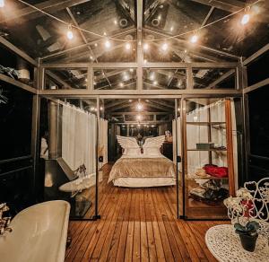 a bedroom with a bed in a room with wooden floors at Chalés Canto do Dragão in Guabiruba