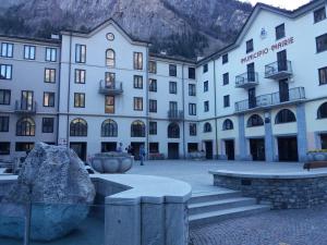 a large white building with a mountain in the background at Maison Clocher in Pré-Saint-Didier +7 photos
