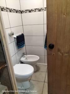 a bathroom with a toilet and a sink at Mini casa a 30 mt dalla spiaggia in Catania