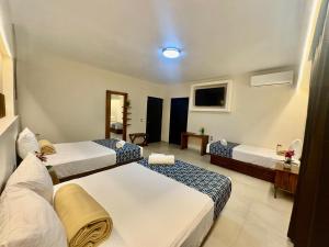 a hotel room with two beds and a television at Hotel Taxaha in Candelaria