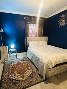 a bedroom with a bed and a blue wall at Modern & cozy 2 bedroom flat in Dundee
