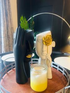 a table with a glass of orange juice and some statues at Modern & cozy 2 bedroom flat in Dundee