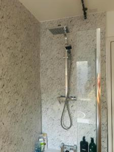a shower in a bathroom with a stone wall at Modern & cozy 2 bedroom flat in Dundee +12 photos