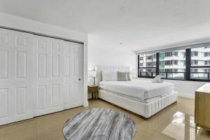 a white bedroom with a bed and a large window at Large Ocean View 2 BDR Condo Beachfront Hotel 504 in Miami Beach +45 photos