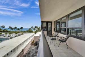 a balcony with chairs and a view of the ocean at Large Ocean View 2 BDR Condo Beachfront Hotel 504 in Miami Beach