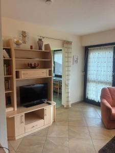 a living room with a tv and a book shelf at Kurring 4 Apartment 105 in Bad Rodach