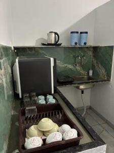 a kitchen with a tray of dishes and a sink at MP Homestay in Godarpura
