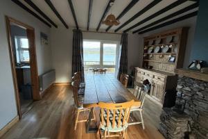 a dining room with a table and a fireplace at Skellig Cottage - Portmagee in Lateeve