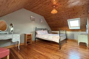 a bedroom with a bed and a desk in a attic at Skellig Cottage - Portmagee in Lateeve