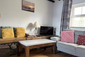 a living room with a couch and a table at Skellig Cottage - Portmagee in Lateeve